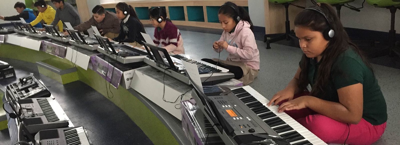 Students playing electronic keyboards in music class